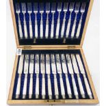 A Martin & Co. stained oak cased set of twelve each ornate silver plated fruit knives and forks with