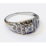 An early 20th Century diamond encrusted white metal ring with stepped shoulders