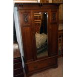 A 3' 9" Art Nouveau walnut single wardrobe with bracketed cornice, flanking decorative panels and