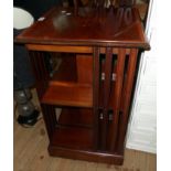 An 18 1/2" Edwardian inlaid mahogany and strung revolving bookcase, set on casters