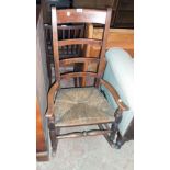 A 19th Century stained oak ladder back rocking chair with woven rush seat, set on turned supports