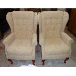 A pair of Sherborne wing back armchairs upholstered in repeat foliate scroll material, set on