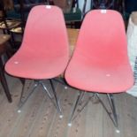 A pair of Ray and Charles Eames design white fibreglass standard chairs with salmon pink