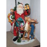 A large ceramic figure of Father Christmas with his sack of toys and a reindeer