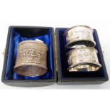 A cased pair of silver napkin rings with engraved decoration and initials - sold with a damaged