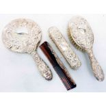 A four piece silver backed hand mirror, brush and comb set in the antique style - Birmingham 2000