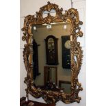 An ornate gilt framed Rococo style wall mirror