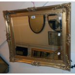 An ornate gilt framed bevelled oblong wall mirror