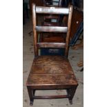 A Georgian oak ladder back rustic rocking chair with solid seat and simple square supports