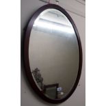 An early 20th Century walnut and strung framed bevelled oval wall mirror