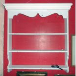 A 3' 2 1/2" painted pine wall mounted three shelf unit with decorative frieze