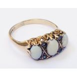 A 9ct. gold ring, set with three opals interspersed with tiny rose diamonds