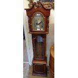 A 4' 9" modern stained wood case Highlands granddaughter clock with visible pendulum, simulated