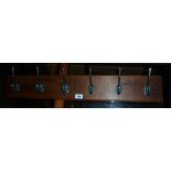 A 33 1/2" wall mounted stained wood coat rack with six hooks