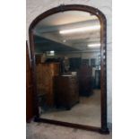 A Victorian walnut framed domed top landing mirror with carved repeat shamrock decorated border