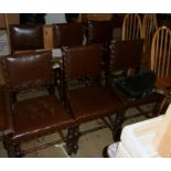 A set of six stained oak framed panel back dining chairs upholstered in studded brown leather, set