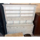 A 6' 8" 20th Century French painted pine three part dresser with shelves and spice drawers on a