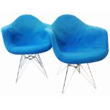 A pair of Ray and Charles Eames design white fibreglass elbow chairs with blue upholstery and chrome