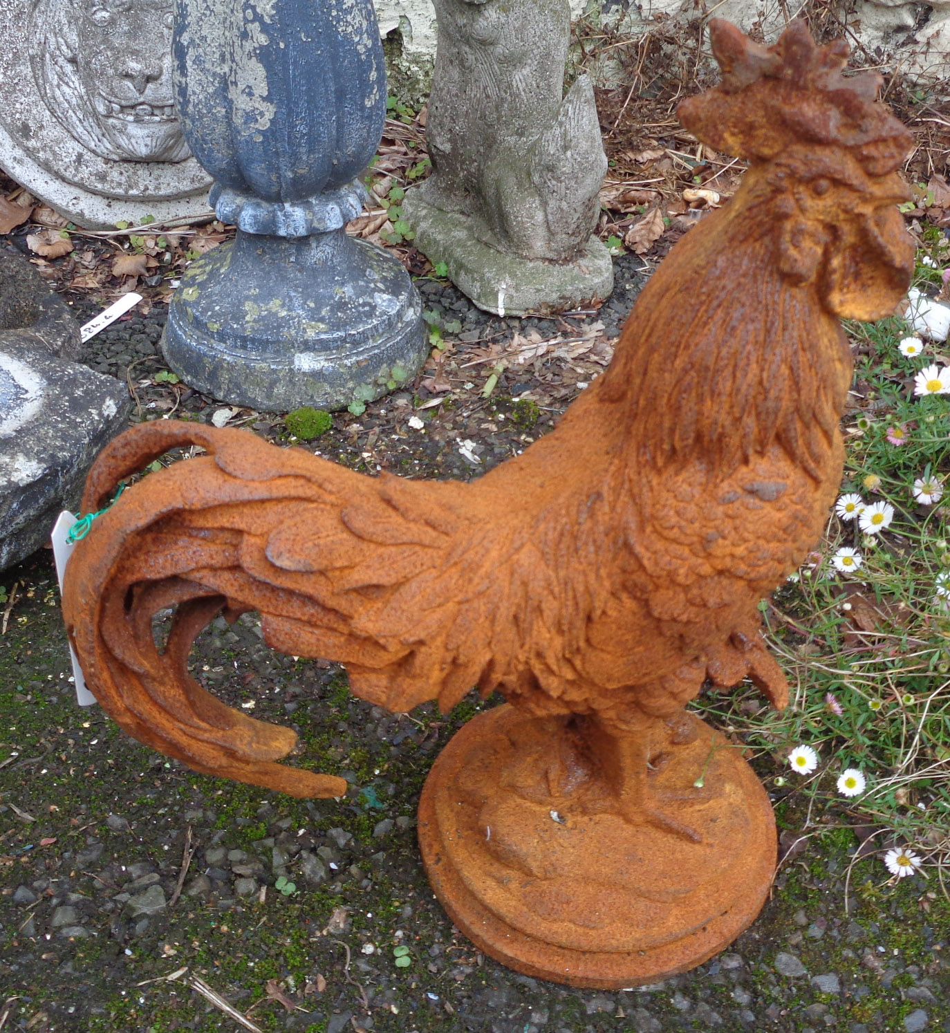 A cast iron garden cockerel with rusted finish