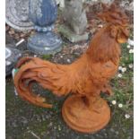 A cast iron garden cockerel with rusted finish