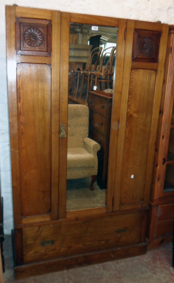 A 3' 7 1/2" early 20th Century stained oak wardrobe with hanging space enclosed by a mirror panel