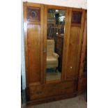 A 3' 7 1/2" early 20th Century stained oak wardrobe with hanging space enclosed by a mirror panel