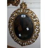 A 20th Century gilded metal framed ornate bevelled oval wall mirror