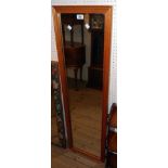 A stained pine framed narrow oblong wall mirror