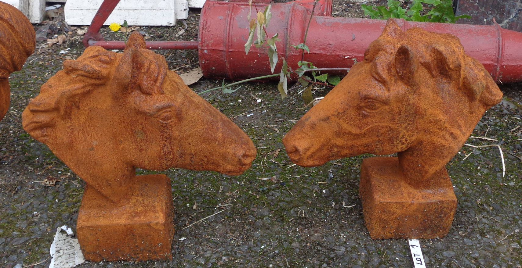 A pair of cast iron garden horse's heads with rusted finish