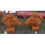 A pair of cast iron garden horse's heads with rusted finish