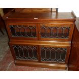 A 35" early 20th Century mahogany waterfall book cabinet with dentil cornice and two pairs of leaded