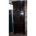 A 36" 19th Century stained walnut and oak lined two part corner cabinet with dentil cornice,