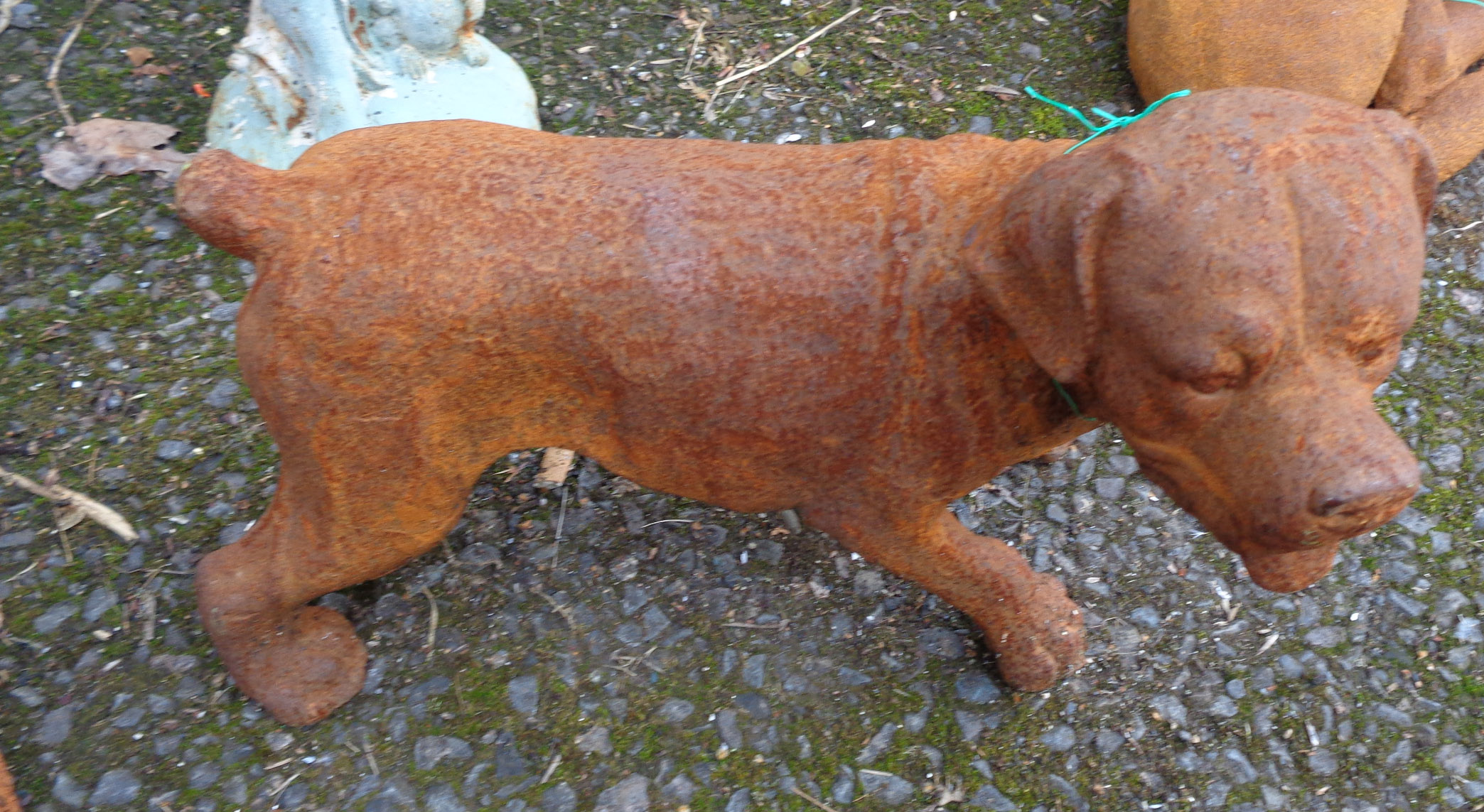 A cast iron garden dog with rusted finish