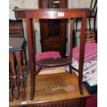 A 26" early 20th Century chevron veneered two tier occasional table set on swept square supports