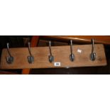 A 27 1/2" rustic oak wall mounted coat rack with five hooks