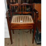 An Edwardian stained beech and stencil lined locker piano stool with arm rests and upholstered