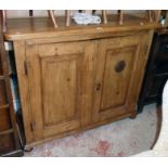 A 4' 1 1/2" 19th Century waxed pine larder cupboard enclosed by a pair of panelled doors, set on