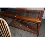 A 4' 5" modern stained wood hall table with brass lined bevelled glass inset top, turned supports