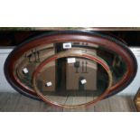 An early 20th Century polished wood and beaded framed bevelled oval wall mirror - sold with another