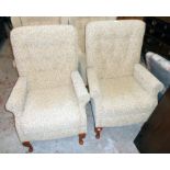 A pair of Sherborne armchairs upholstered in repeat foliate scroll material, set on polished wood