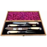 A late Victorian oak cased four piece carving set with silver mounts to the ivory pistol grip