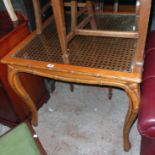 A 35" antiqued stained wood grained table in the Oriental style with rattan panel under inset