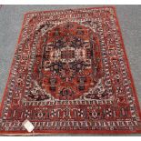 A machine made floral pattern rug with central medallion within repeat border, cream and black on