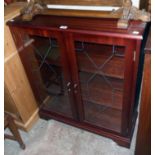 A 33" New Plan mahogany effect book cabinet enclosed by a pair of etched glazed panel doors, set