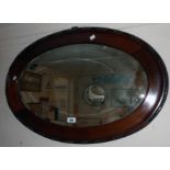 An early 20th Century beaded walnut framed bevelled oval wall mirror