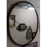 A retro teak framed oval wall mirror