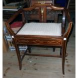 An Edwardian stained mahogany locker piano stool with stencilled decoration, arm rests and
