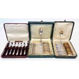Two cased sets of twelve French white metal teaspoons, one set with parcel gilt bowls - sold with