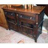 A 4' 20th Century oak sideboard in antique style with two drawers and pair of panelled doors under