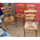 A set of four modern stained beech framed ladder back kitchen chairs with woven rush seats and
